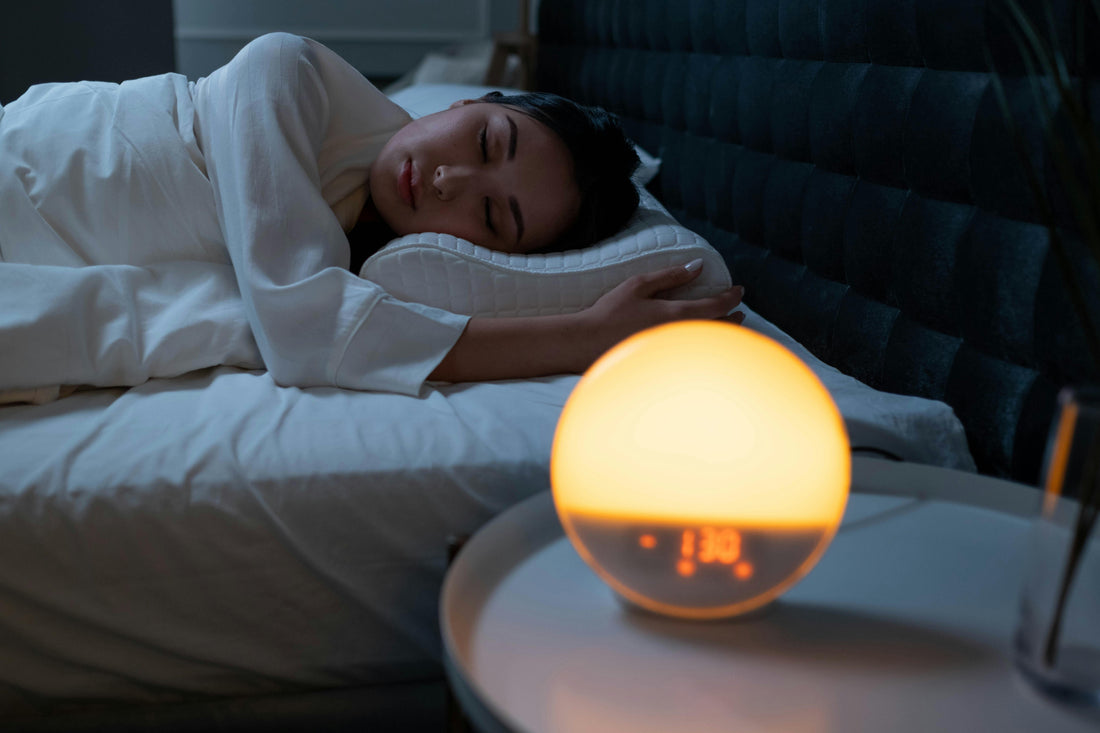 Woman lying in bed with the alarm clock on, watching the clock, somniophobia.