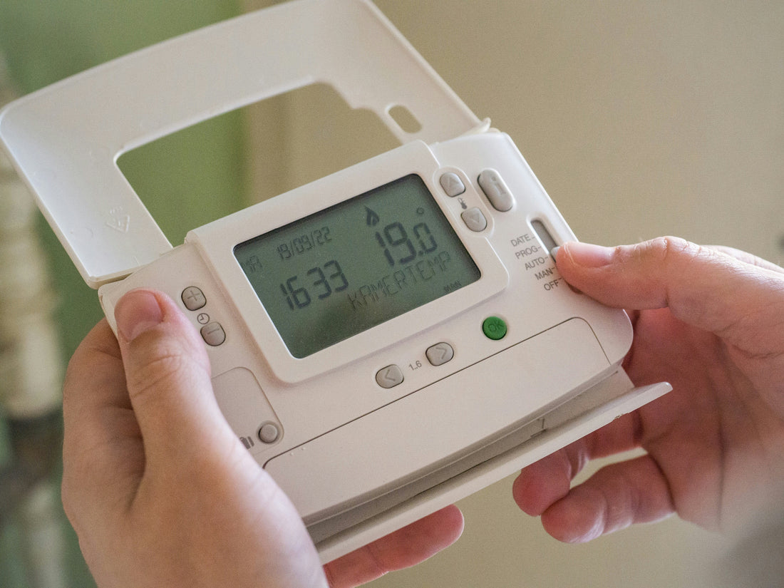 Adjusting a bedroom thermostat to 19 degrees celsius for optimal sleep temperature and fat burning.