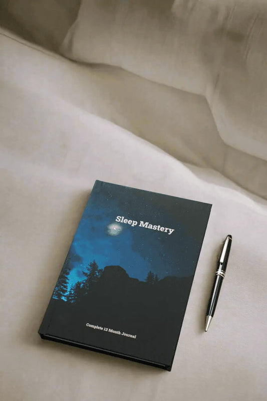 Sleep Mastery Journal against a background of pillows and duvets, ready to be used before going to bed.